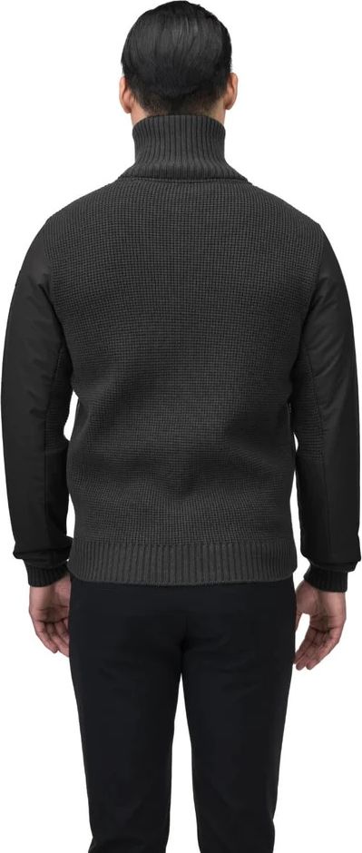 Man wearing a black turtleneck sweater and black pants, back view.