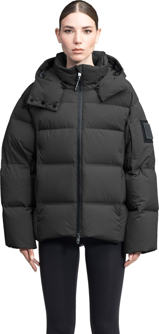 A person wearing a black puffer jacket with a hood and black leggings.