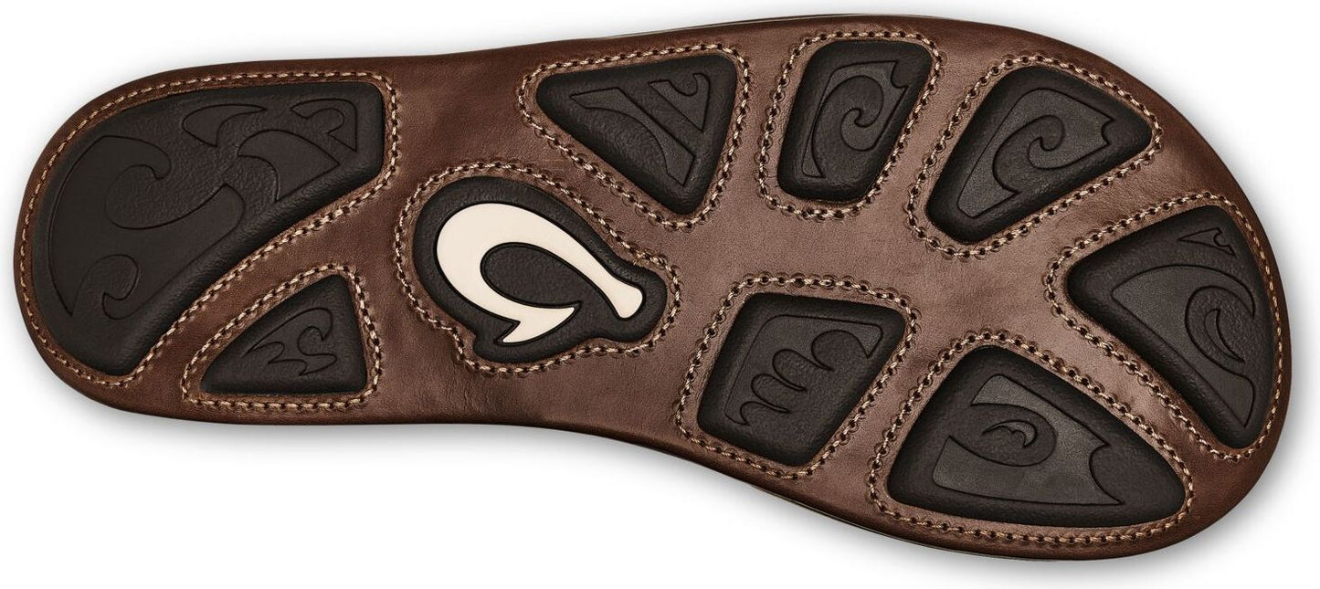 The brown sole of a sandal with black traction pads featuring wavy designs and a white logo.