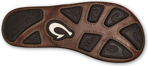 The brown sole of a sandal with black traction pads featuring wavy designs and a white logo.