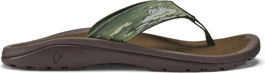 A flip-flop with a green camouflage strap and a dark brown sole.