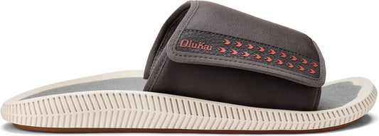 A brown and beige slide sandal with the brand name Olukai stitched onto the upper band.