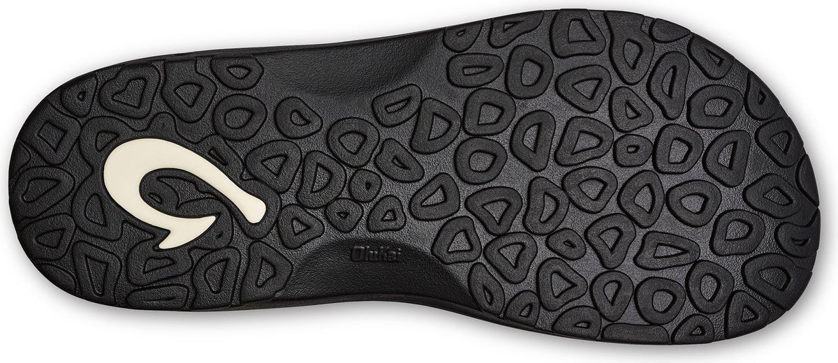 Bottom of a black sandal with a white hook logo and a pattern of rounded shapes.