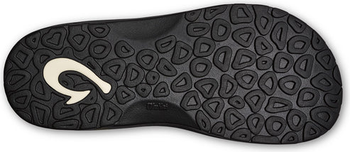 Bottom of a black sandal with a white hook logo and a pattern of rounded shapes.