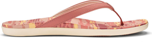 A pink sandal with geometric patterning on the footbed and a flat sole.