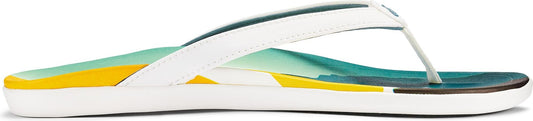 A white flip-flop with a white strap and a colorful yellow, aqua, and teal insole.