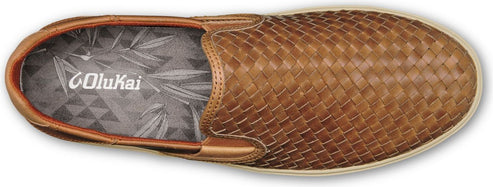 A brown woven slip-on shoe with a white sole, viewed from above, featuring a logo on the insole.