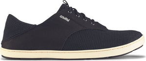 A black sneaker with a white sole and the word "Olukai" visible.