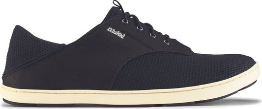 A black sneaker with a white sole and the word "Olukai" visible.