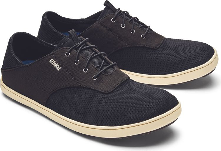 A pair of low-top, black lace-up shoes with a tan sole.