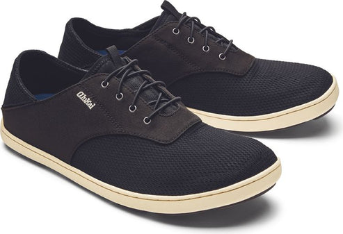 A pair of low-top, black lace-up shoes with a tan sole.