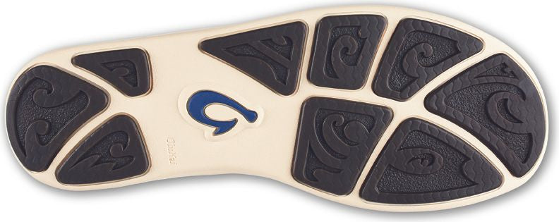 Bottom view of a shoe with cream-colored base and dark brown decorative treads.