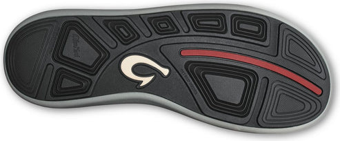 Close-up of the bottom of a shoe with a gray trim, patterned black tread, a white logo, and a red stripe.