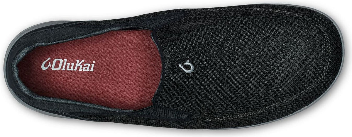 A black slip-on shoe with a red insole that has the brand's logo printed on it.