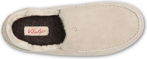 A beige slipper with the brand label 'OluKai' visible on the inner sole.