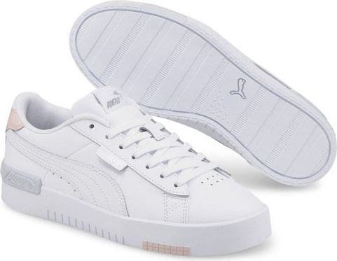 A low-profile white sneaker with a flat white sole, white laces and a small silver accent at the heel.
