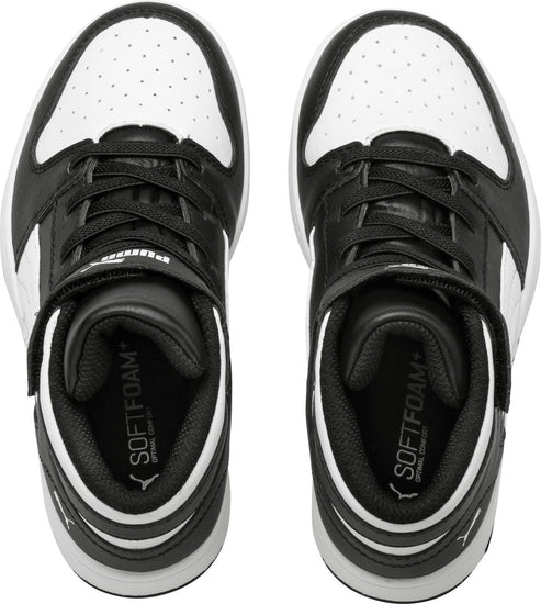 Overhead view of black and white high top sneakers with velcro straps.