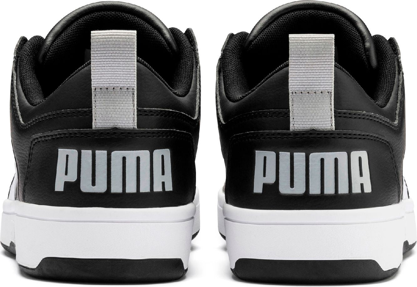 Rear view of black and white sneakers with the word PUMA printed in silver.