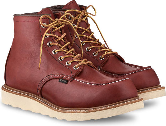 Pair of red leather work boots with white sole and yellow laces.