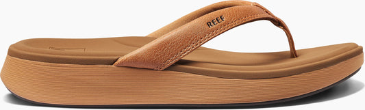 A brown sandal with the word REEF on the strap.