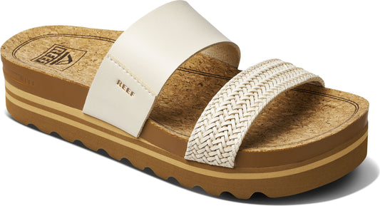 A pair of Reef branded platform sandals with a cork footbed and two straps, one white and one woven.