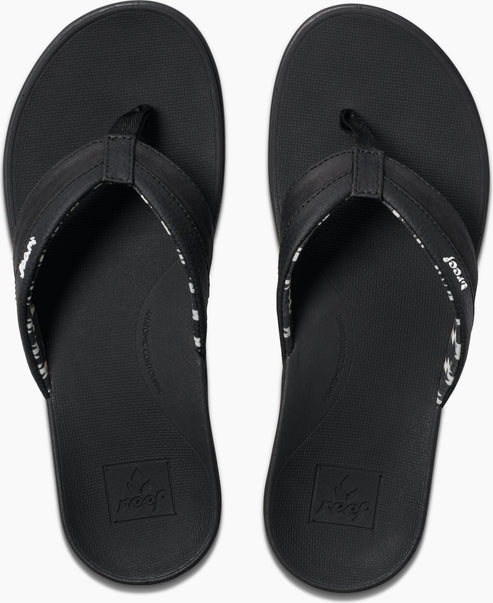 Overhead view of a pair of black flip-flops with a logo at the footbed.