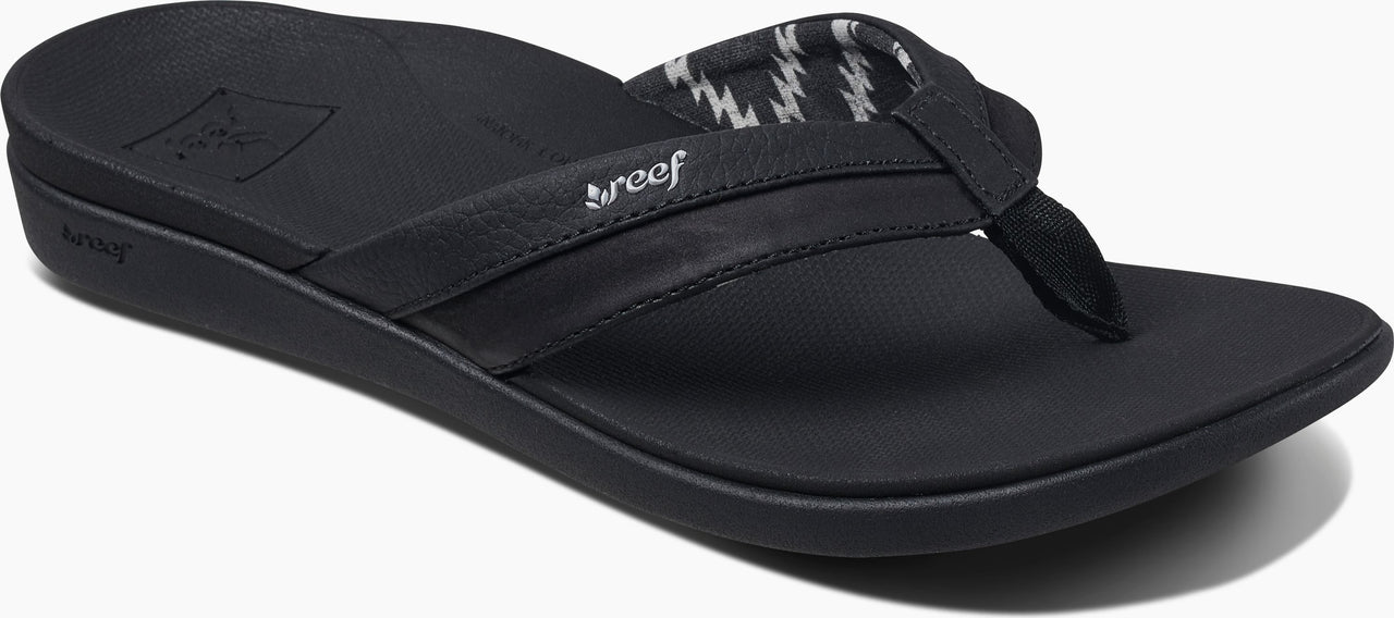 A black sandal with a patterned strap.