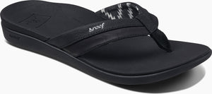 A black sandal with a patterned strap.