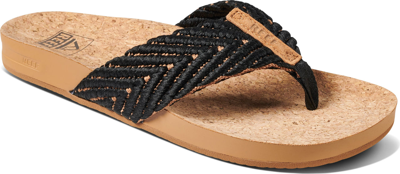 A tan platform sandal with black woven straps.