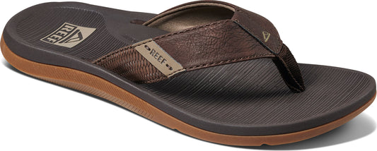 A brown flip-flop sandal with a toe post and a strip with the word REEF on the side.
