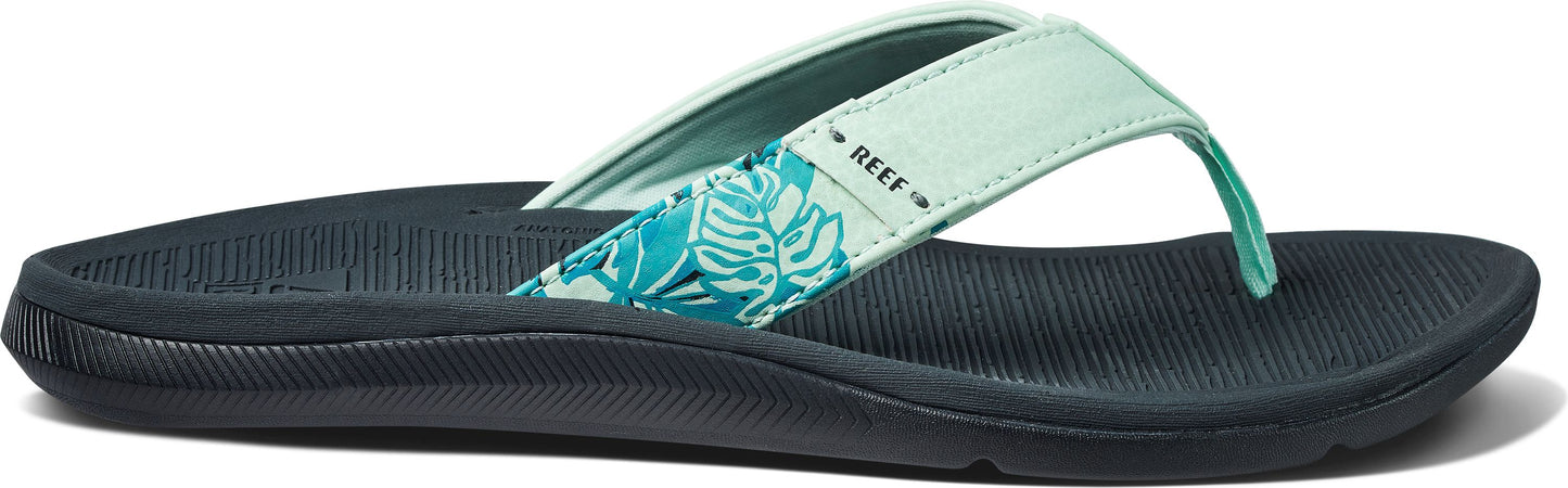 A flip-flop with floral print and the text "REEF".
