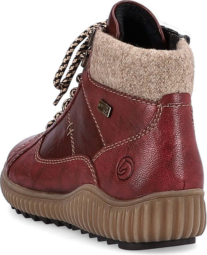 Red ankle-high boot with laces and ridged tan sole.