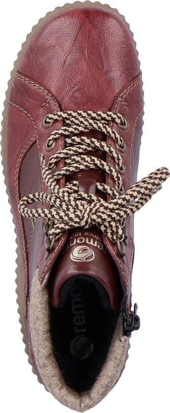 A top-down view of a high-cut maroon boot with patterned laces.