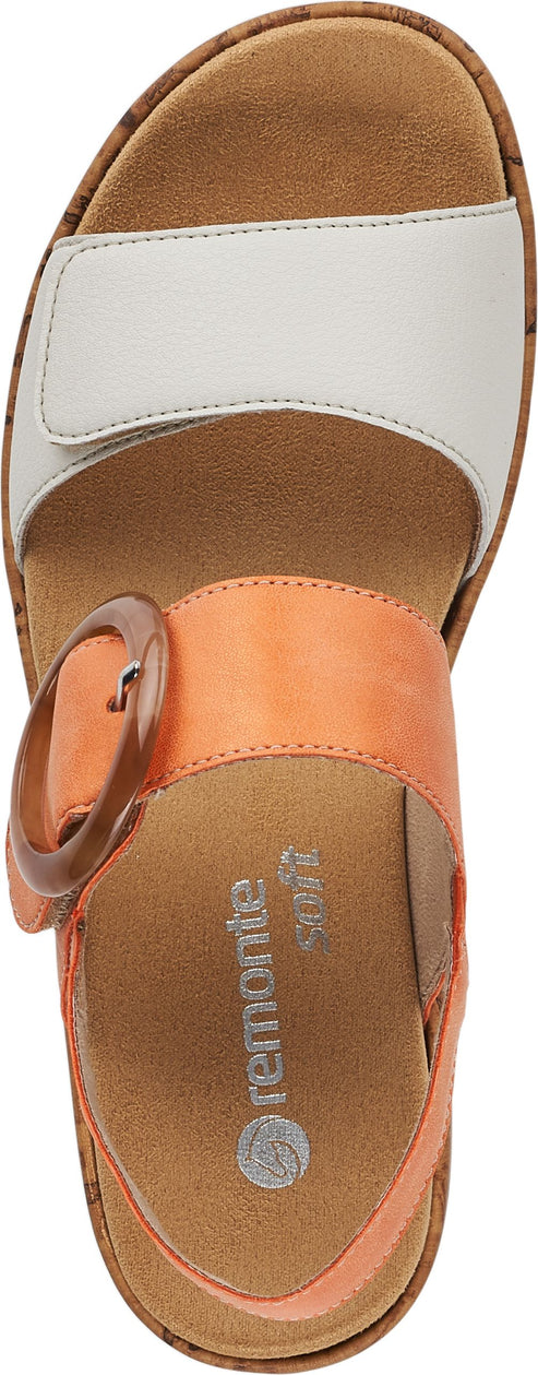 Overhead view of a sandal with a white front strap, orange instep strap with a round buckle, and cork soles.