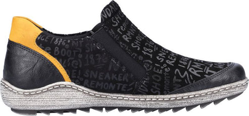 A slip-on shoe with black leather and printed word pattern, featuring a gold accent at the heel.