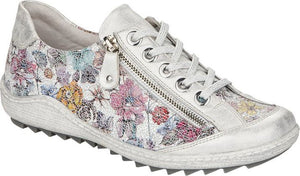 Floral print low-rise sneaker with silver accents, laces and a side zipper.
