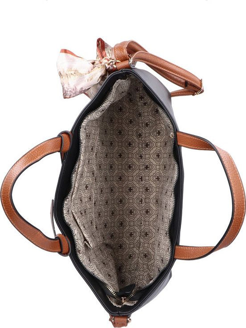 Open black tote bag with brown leather handles and decorative scarf showing patterned interior lining.