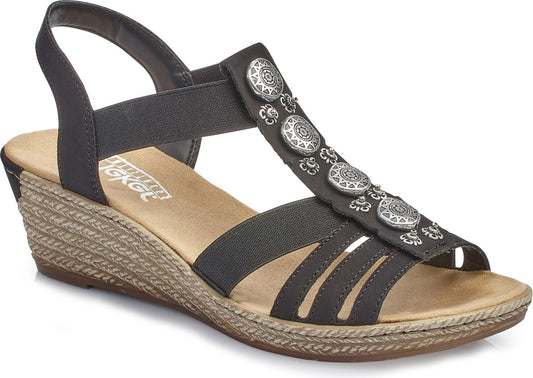 Dark gray wedge sandals with elastic straps and decorative circular medallions.