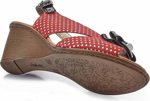 Low angle view of red and white polka dot sandal with black embellishment and a buckle strap.