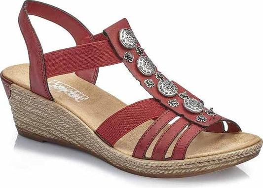 Red wedge sandal with metallic disc embellishments and elastic straps.