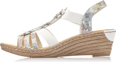 Wedge heel sandal with straw-textured sole, white straps, a floral accent, and patterned fabric.