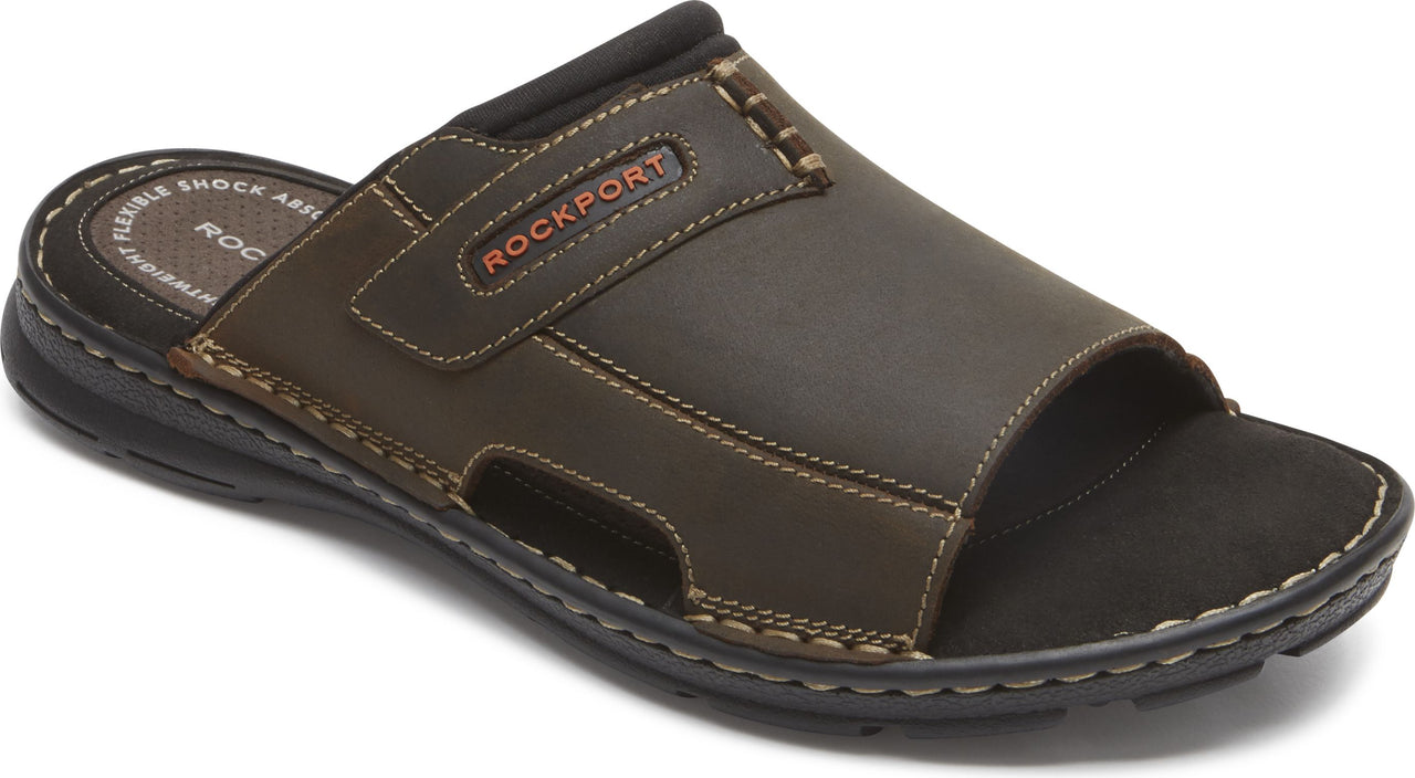 Brown leather slide sandal with black sole and the word ROCKPORT.
