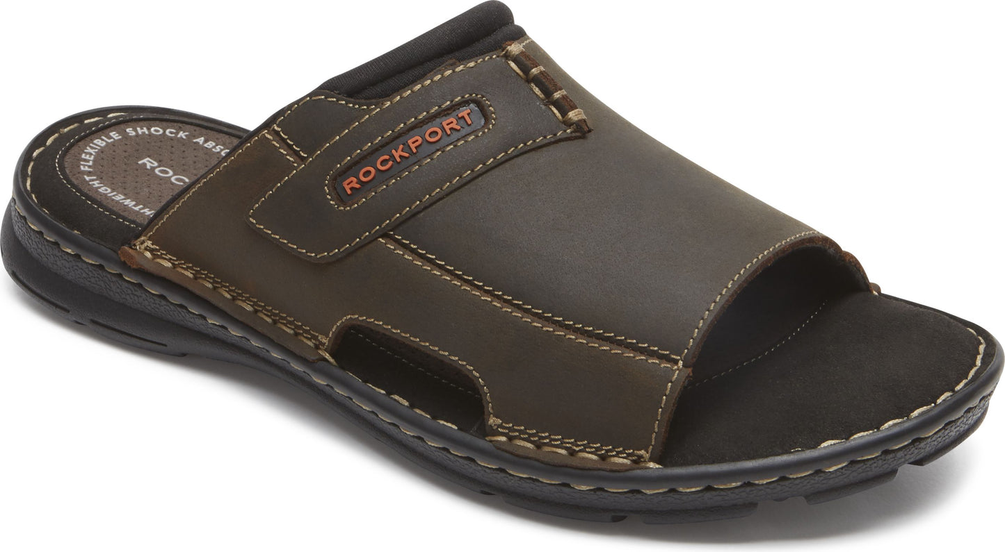 Brown leather slide sandal with black sole and the word ROCKPORT.