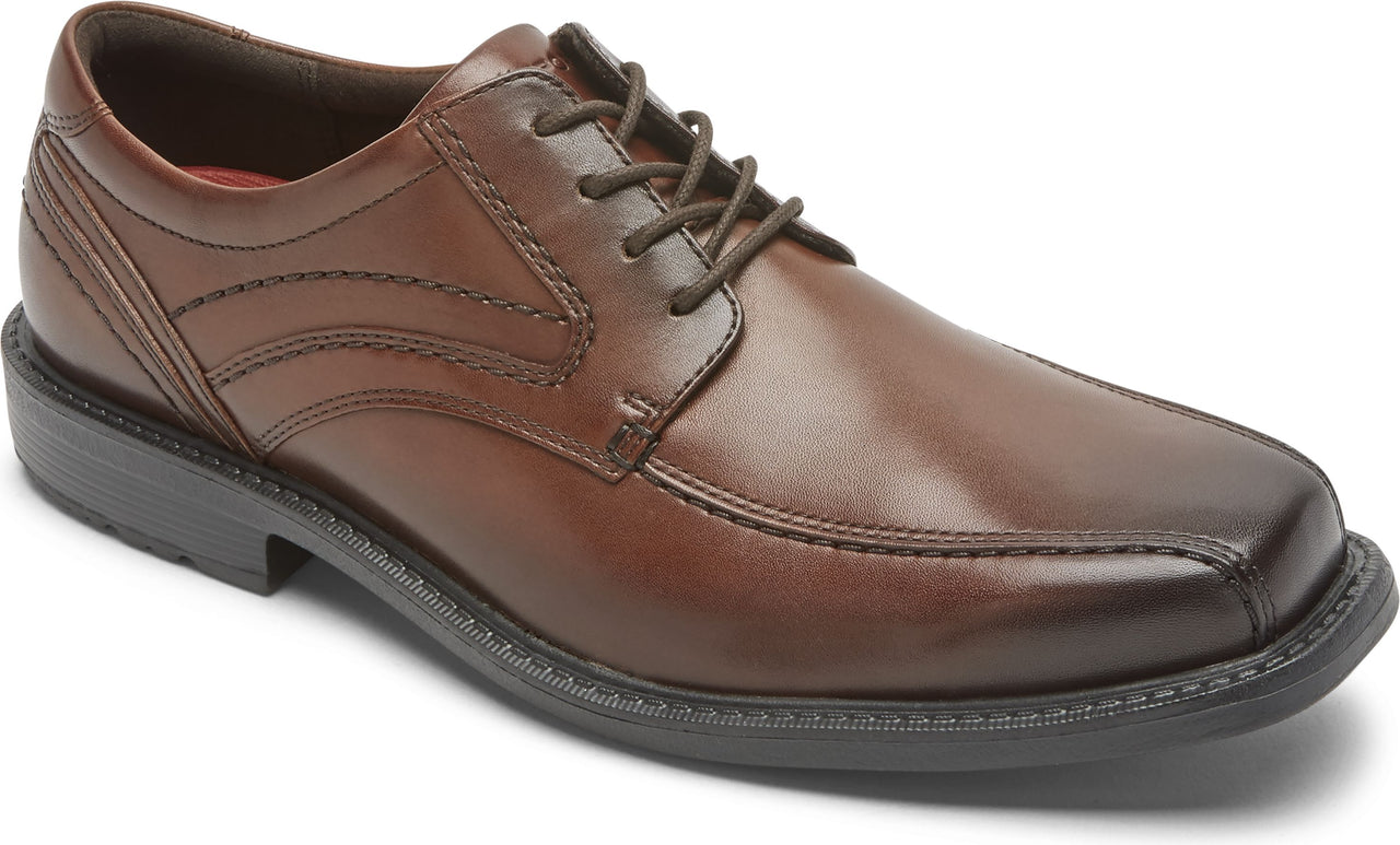 A brown leather lace-up dress shoe with a rounded square toe.