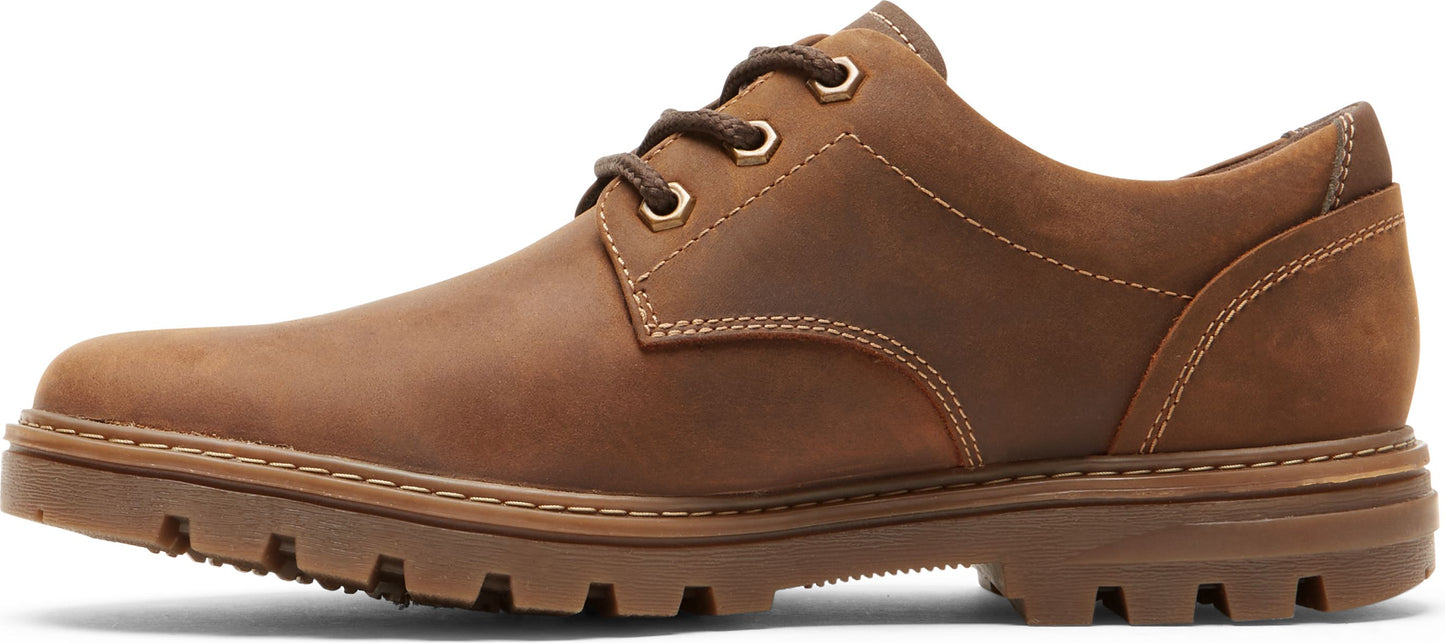 Brown leather shoe with a lace-up closure and a lug sole.