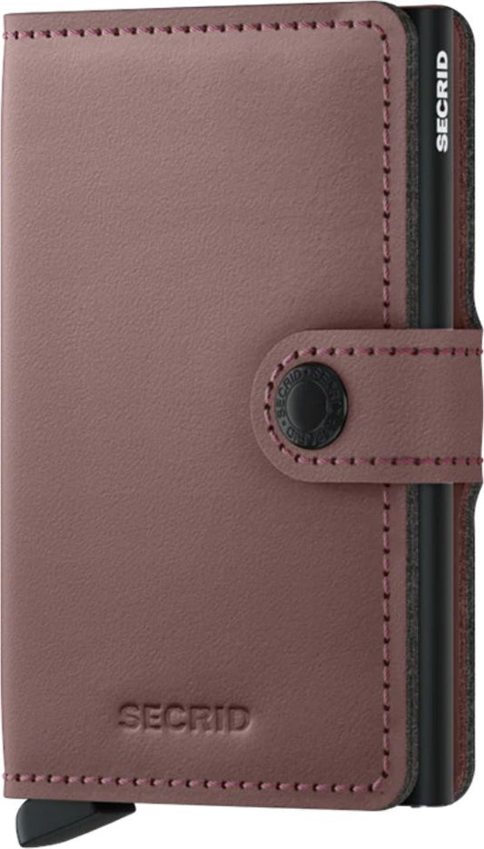 Closed pink leather wallet with a black button strap.