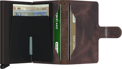 Open wallet with a dark metal card holder on the left with money inside, and a brown leather card holder on the right with cards inside.