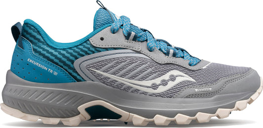 A side view of a trail running shoe with a gray mesh upper, teal accents, and a white logo.