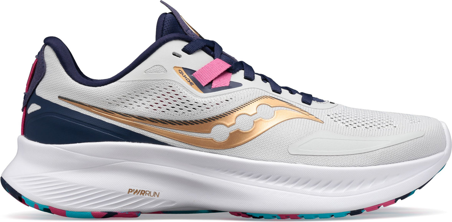 A running shoe in white with gold stripes, pink accents, and a thick white sole.