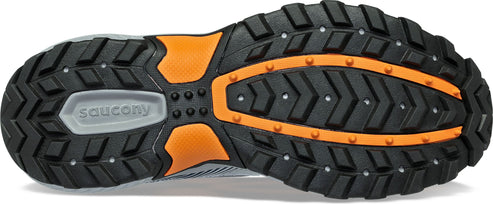 A shoe sole with black tread, small silver studs, orange trim, and a grey Saucony logo.
